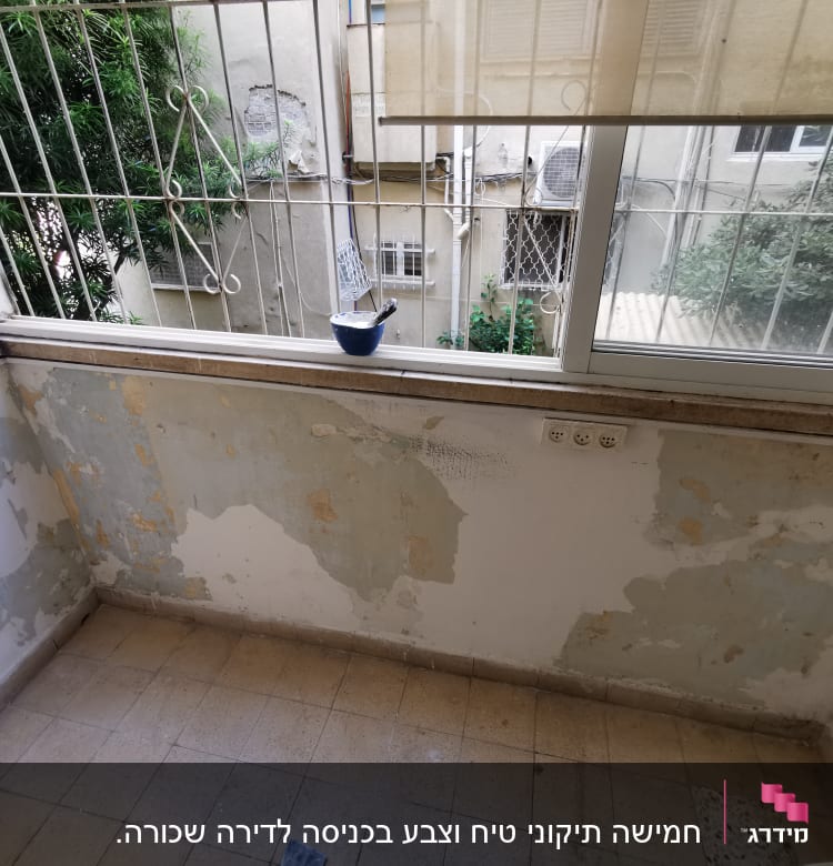 קיר מתקלף עם מברשת צבע על אדן החלון